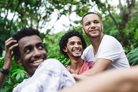 Three young men embrace and enjoy the outdoors together