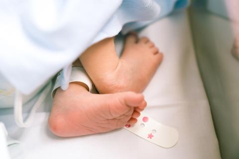 A newborn baby's foot, after receive one of the three primary newborn screen procedures after birth, the heel stick blood test.
