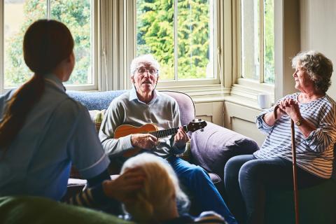 A nursing home resident joyfully plays music for others 