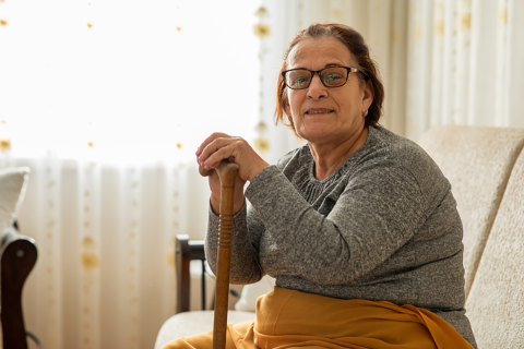 Older woman holding a cane. 
